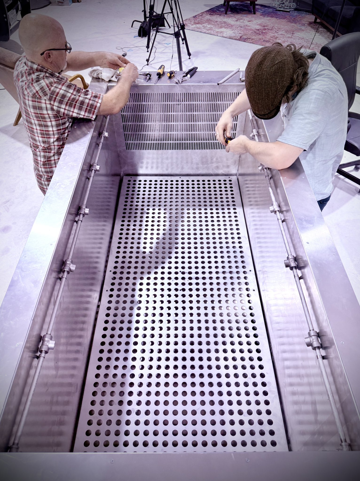 Technicians working on the Cryopets stainless steel slow-cooling chamber with internal piping and a perforated floor